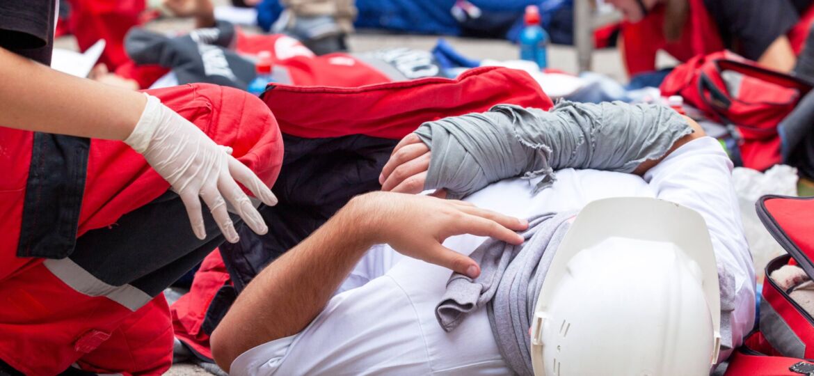 Two paramedics help an injured construction worker