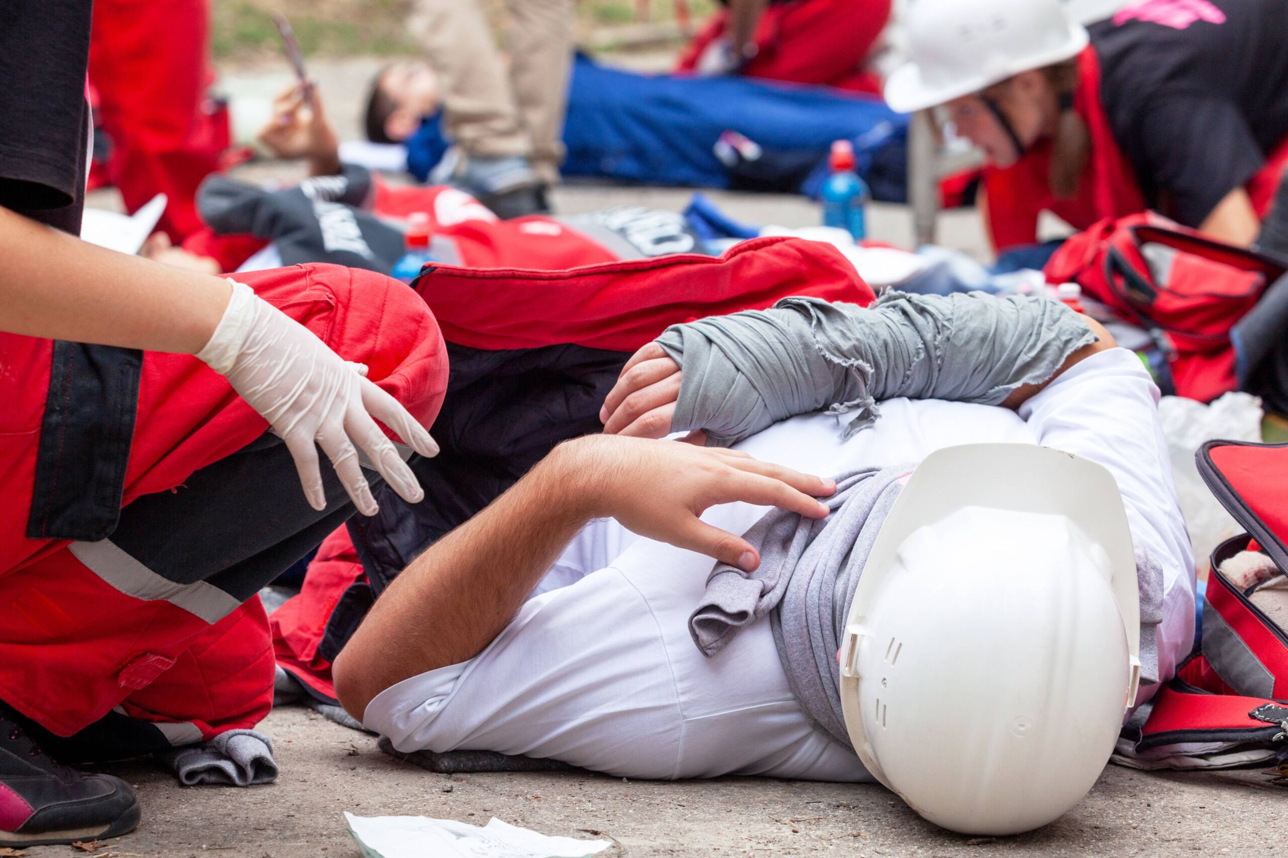 Two paramedics help an injured construction worker